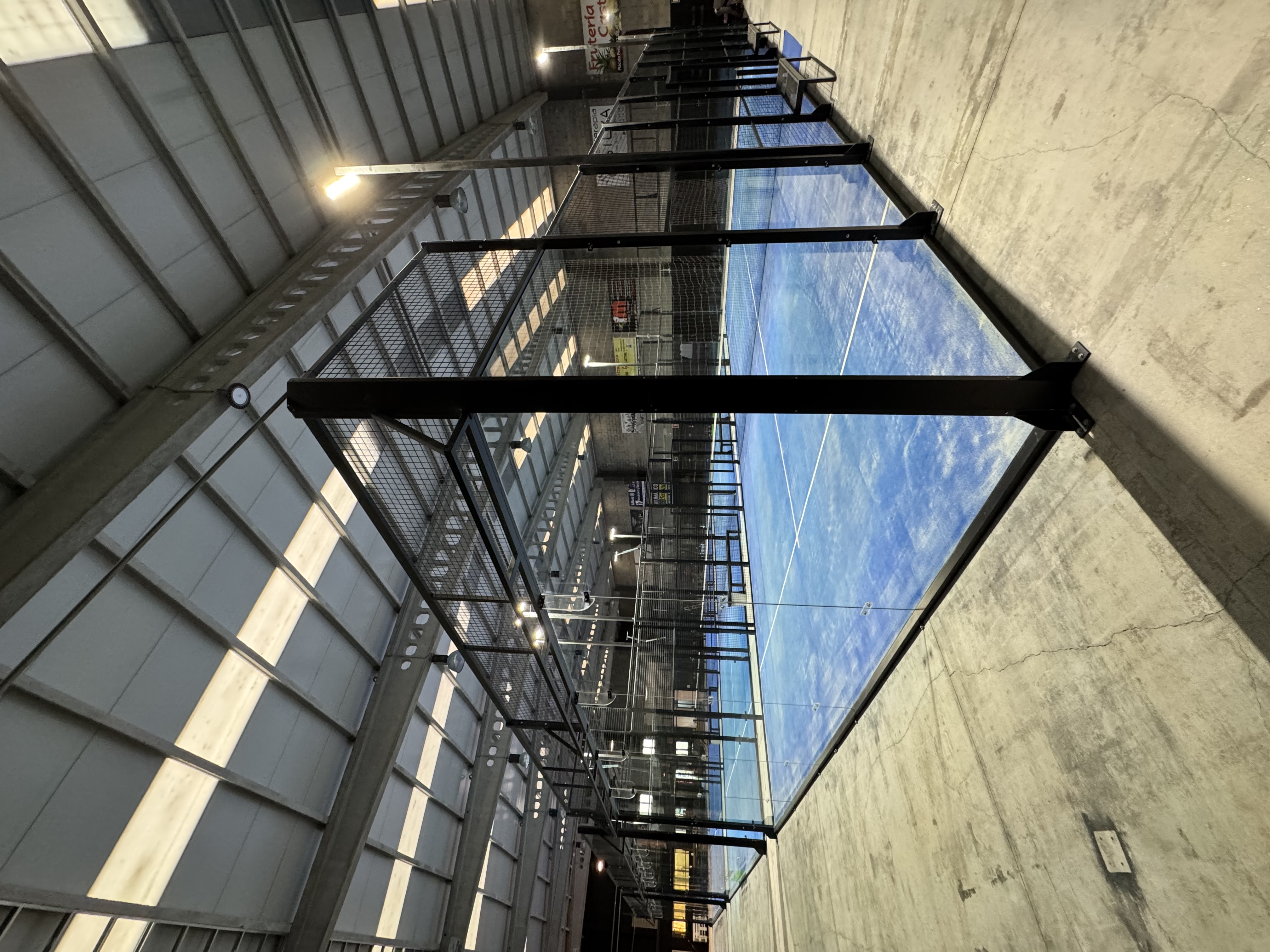 Pista de pádel panorámica indoor con césped azul en INDOOR Vilalba, Club de Pádel